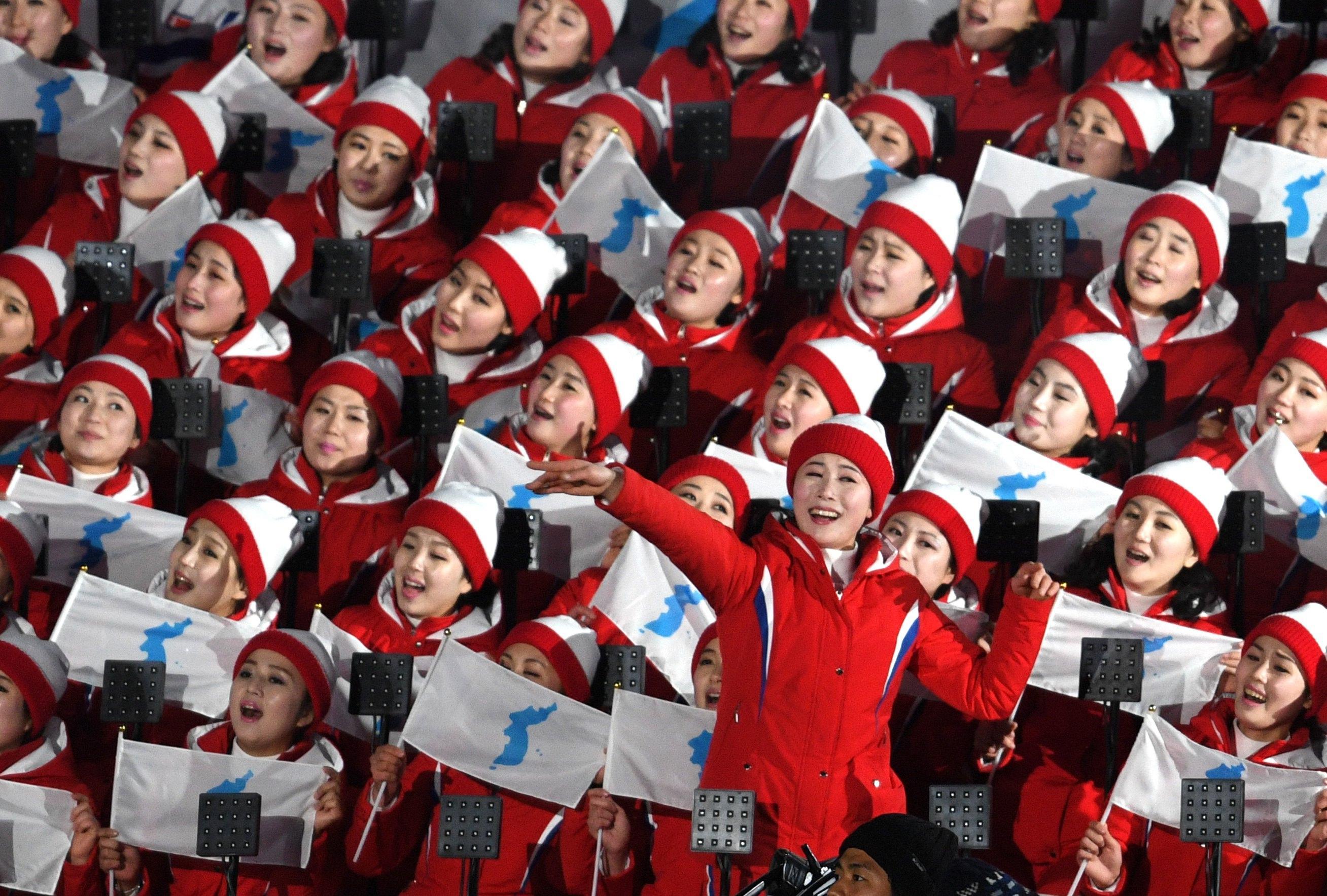 I coreani cantano tenendo la bandiera dell'unificazione coreana durante la pre-cerimonia