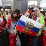 Un gruppo di turisti russi posa per una foto con i volontari olimpici nella stazione di Jinbu nella città olimpica