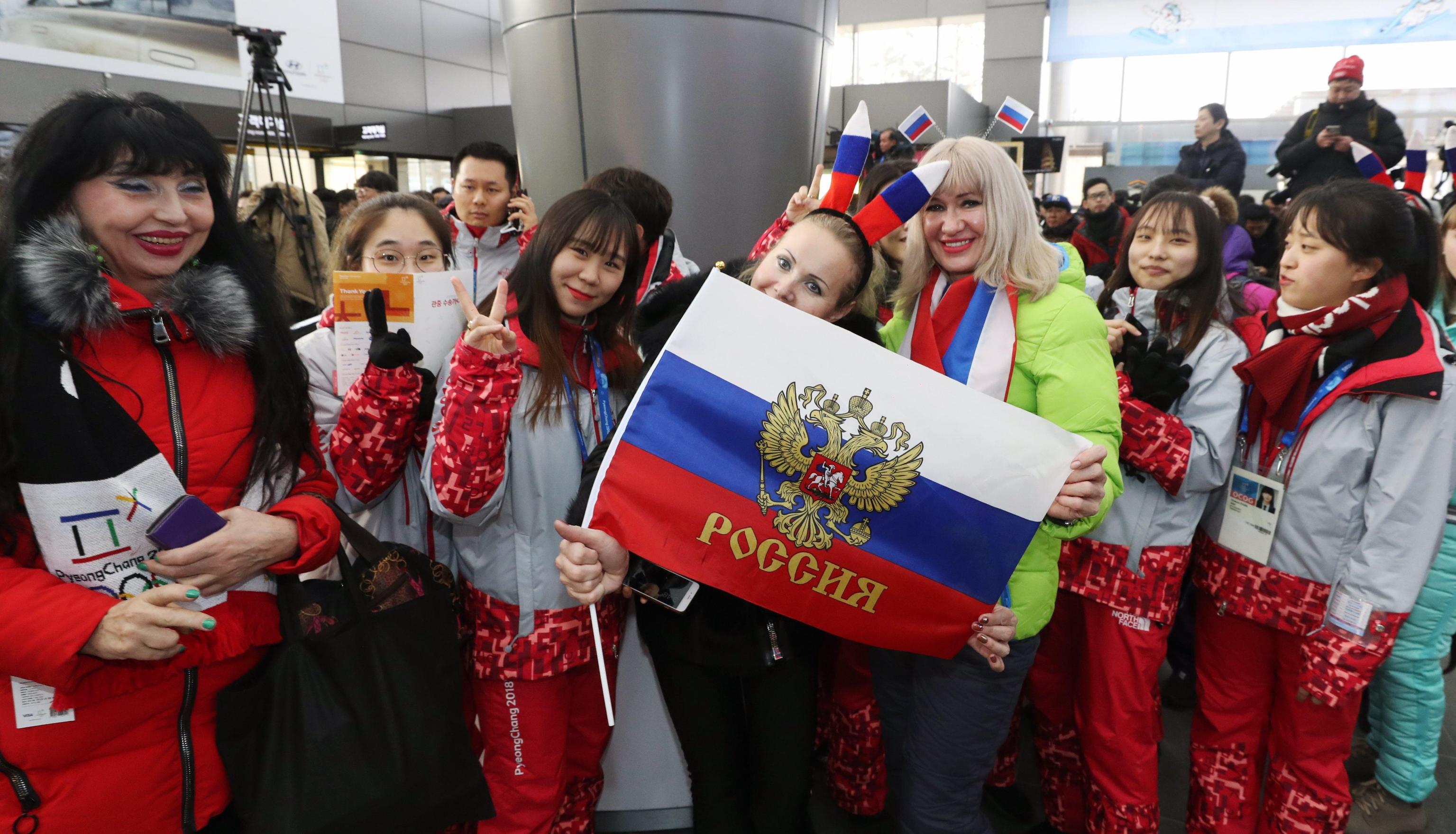 Un gruppo di turisti russi posa per una foto con i volontari olimpici nella stazione di Jinbu nella città olimpica