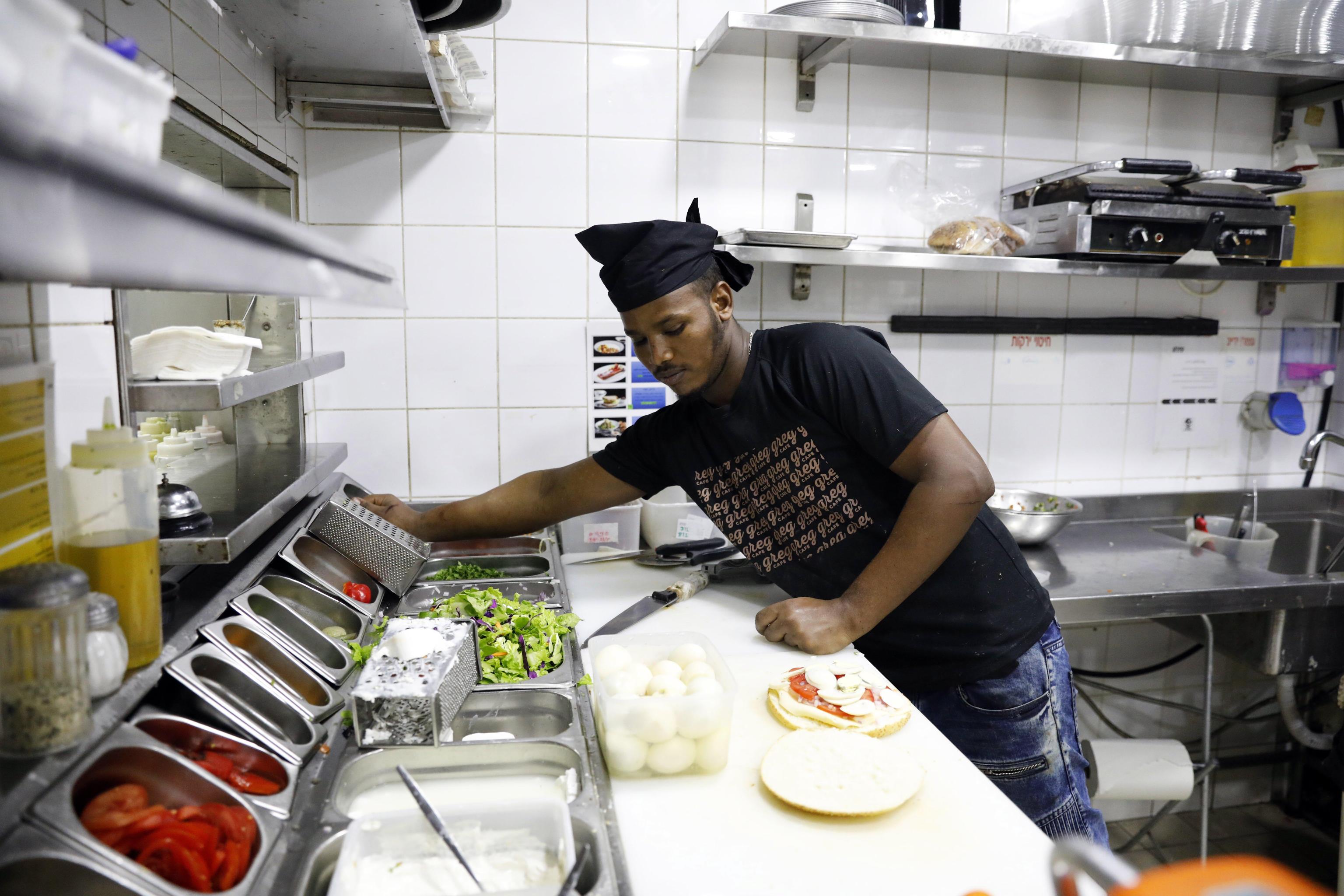 Awet Tewlede richiedente asilo eritreo, mentre lavora in una caffetteria a Tel Aviv