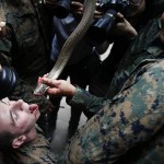 Gli addestratori thailandesi fanno sgocciolare il sangue dei serpenti, uccisi poco prima, nelle bocche dei militari