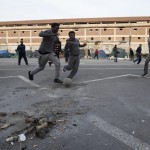 Migranti che giocano a pallone nella tendopoli a Tiburtina Migranti che giocano a pallone nella tendopoli a Tiburtina