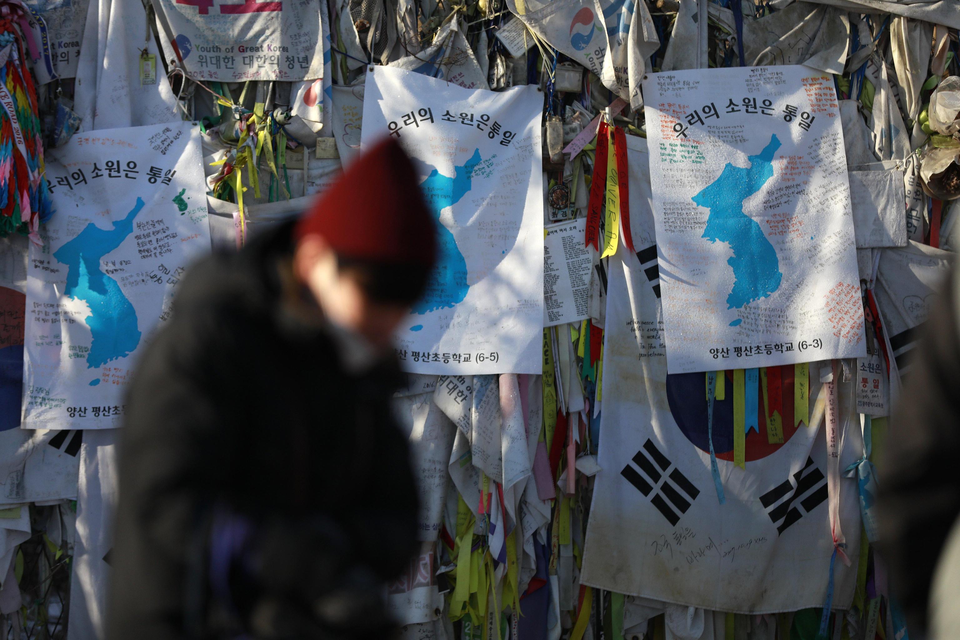 Sullo sfondo immagini della penisola coreana con un unico colore, ovvero unita