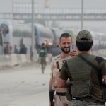 I soldati siriani posano per fotografie di fronte a una linea di autobus noleggiati dal governo