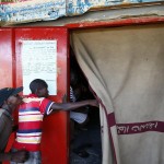 Un bambino sbircia da dietro la tenda, forse non si è potuto permettere il biglietto d'ingresso