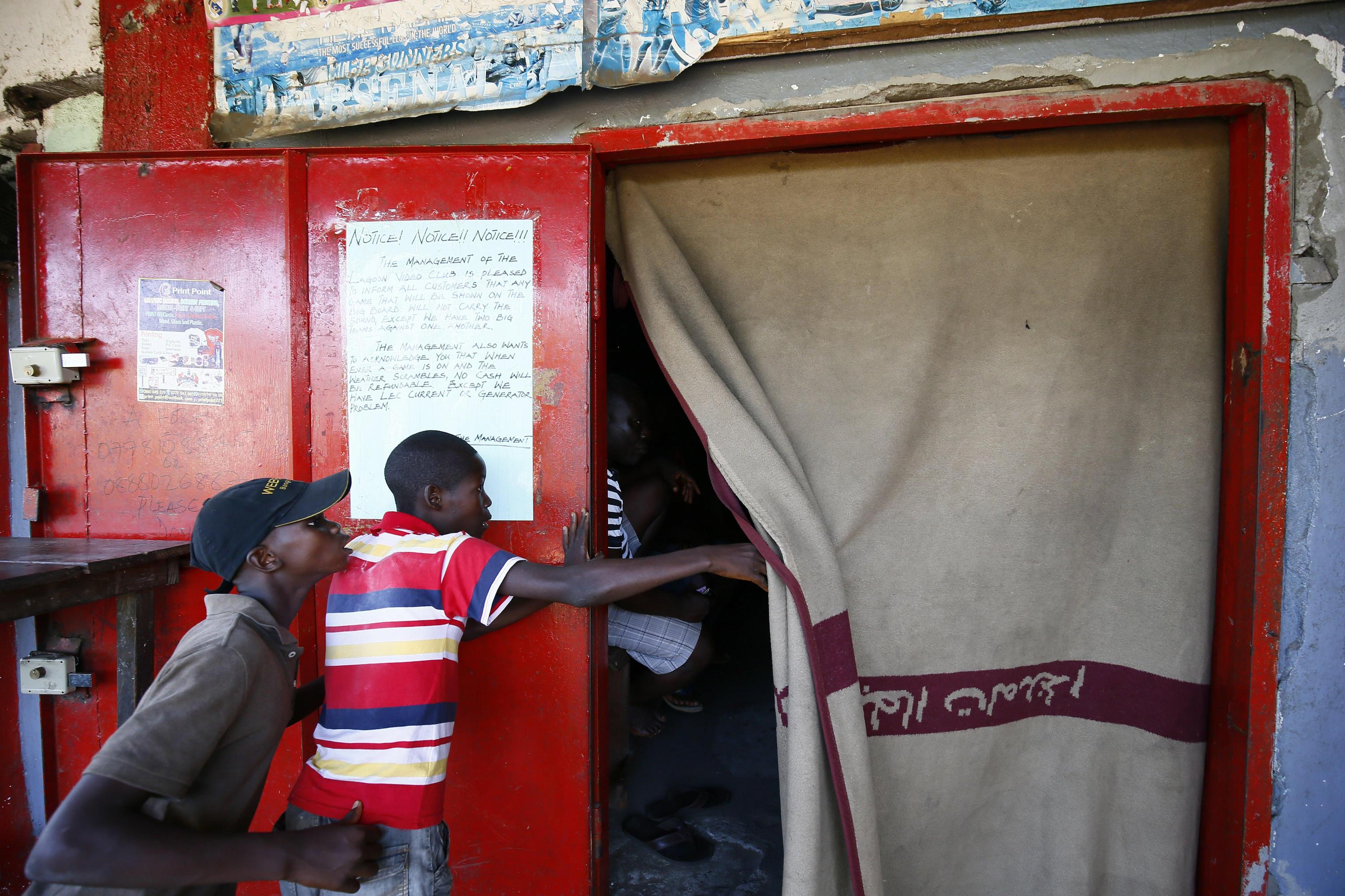Un bambino sbircia da dietro la tenda, forse non si è potuto permettere il biglietto d'ingresso