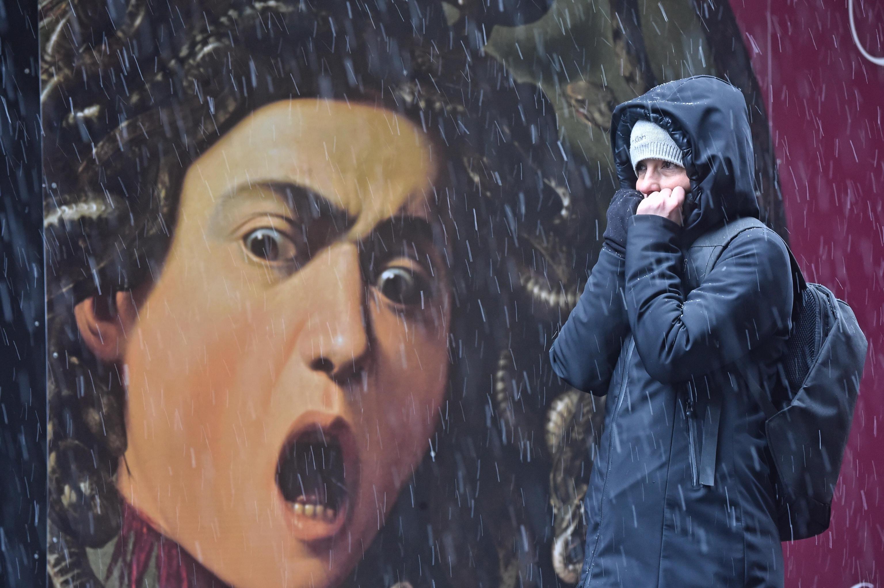 Una turista cammina per le strade di Firenze durante la nevicata