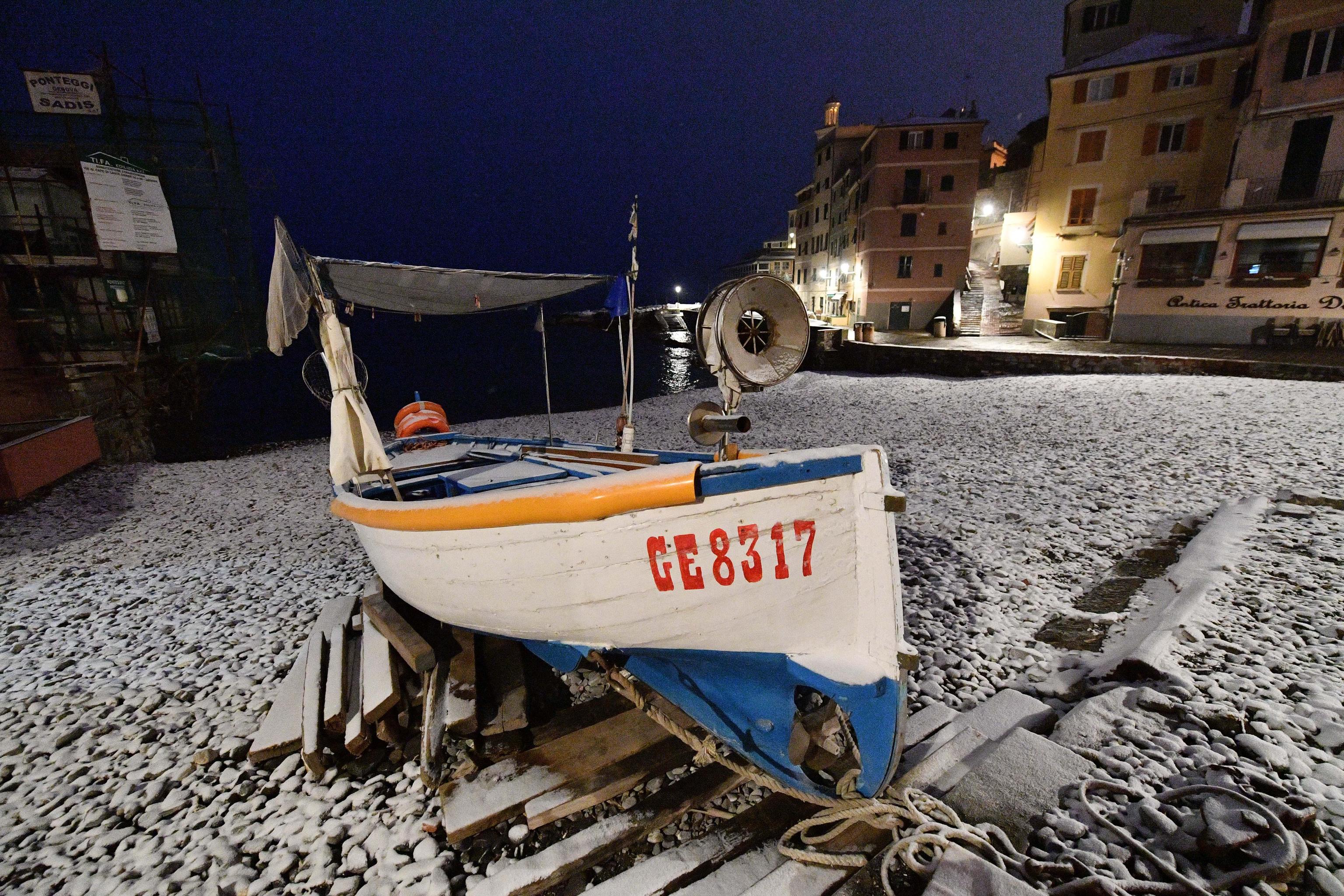 La spiaggetta di Boccadasse a Genova con i ciottoli imbiancati dalla neve