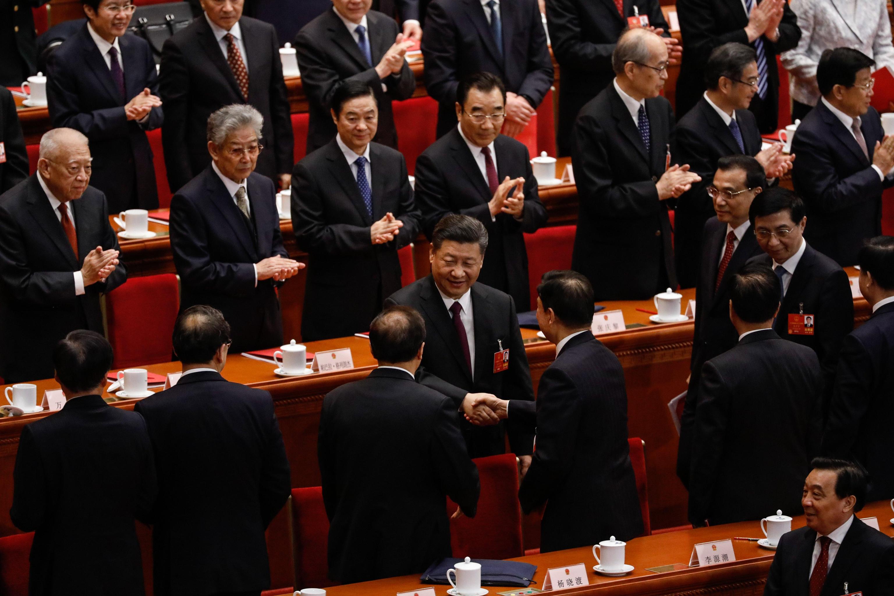 Il presidente cinese Xi Jinping stringe le mani ai delegati del parlamento riunito
