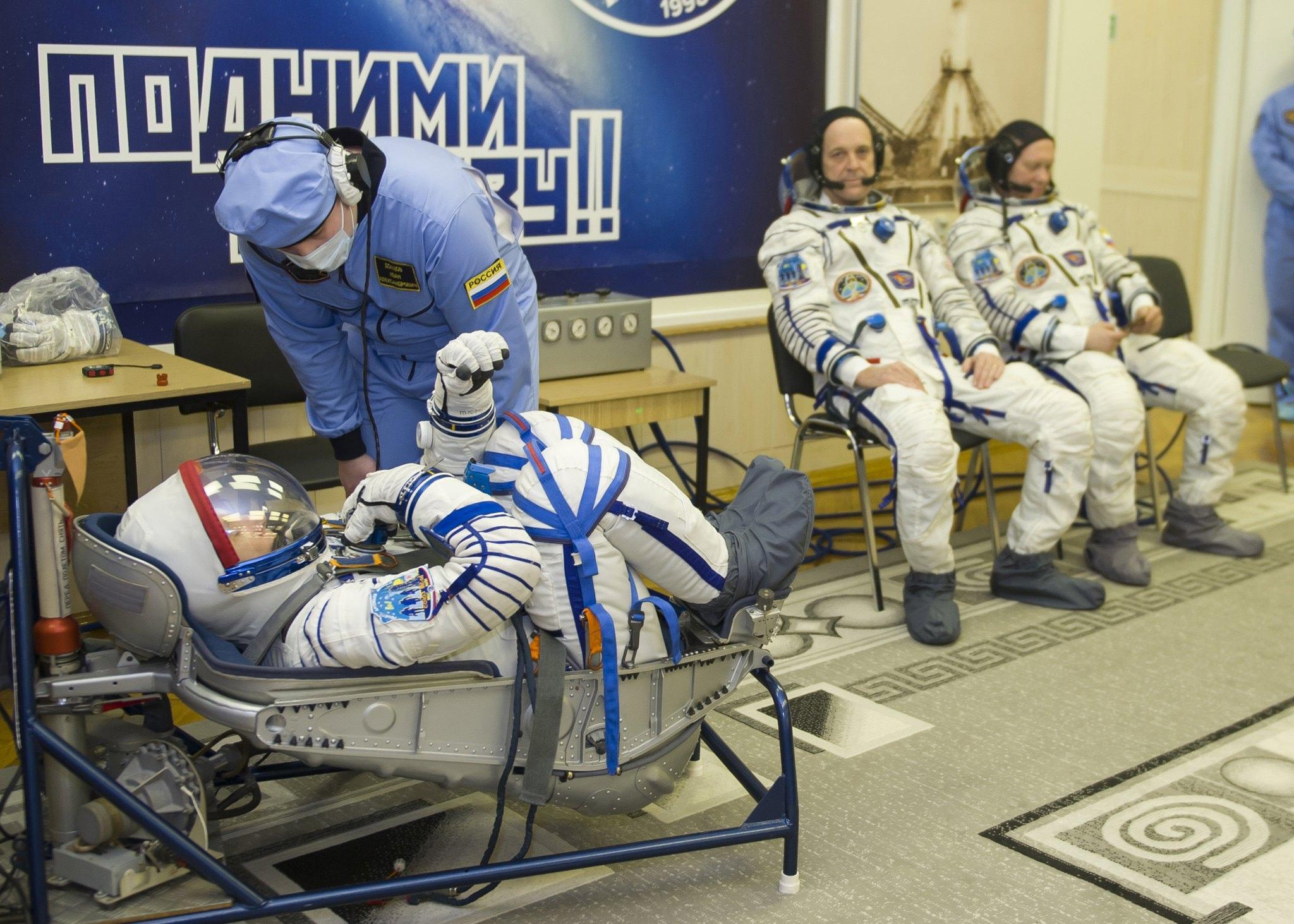 I membri dell’equipaggio vengono aiutati dagli specialisti prima di salire sulla Soyuz