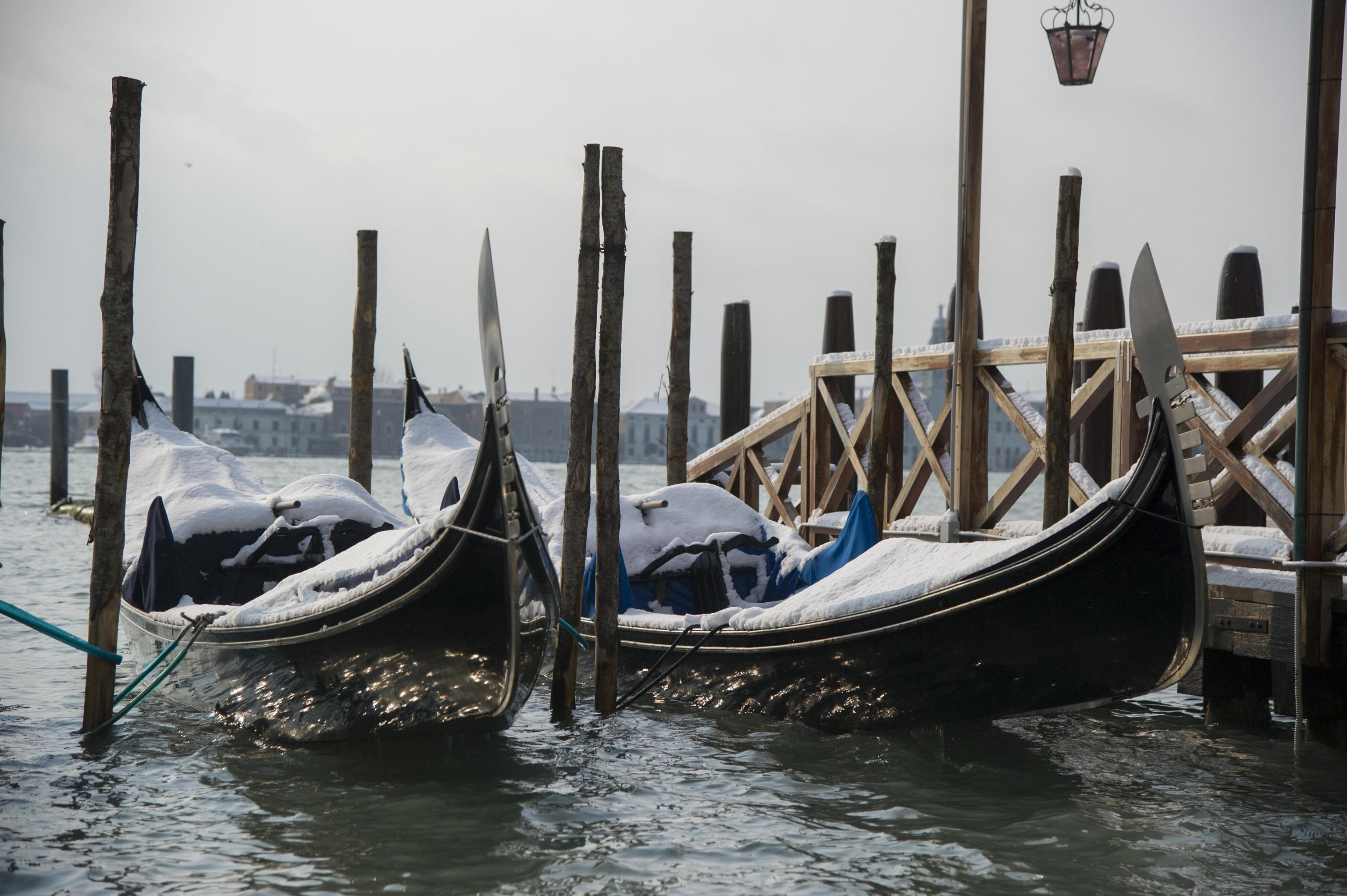 Le gondole ormeggiate nella laguna di Venezia ricoperte dalla neve