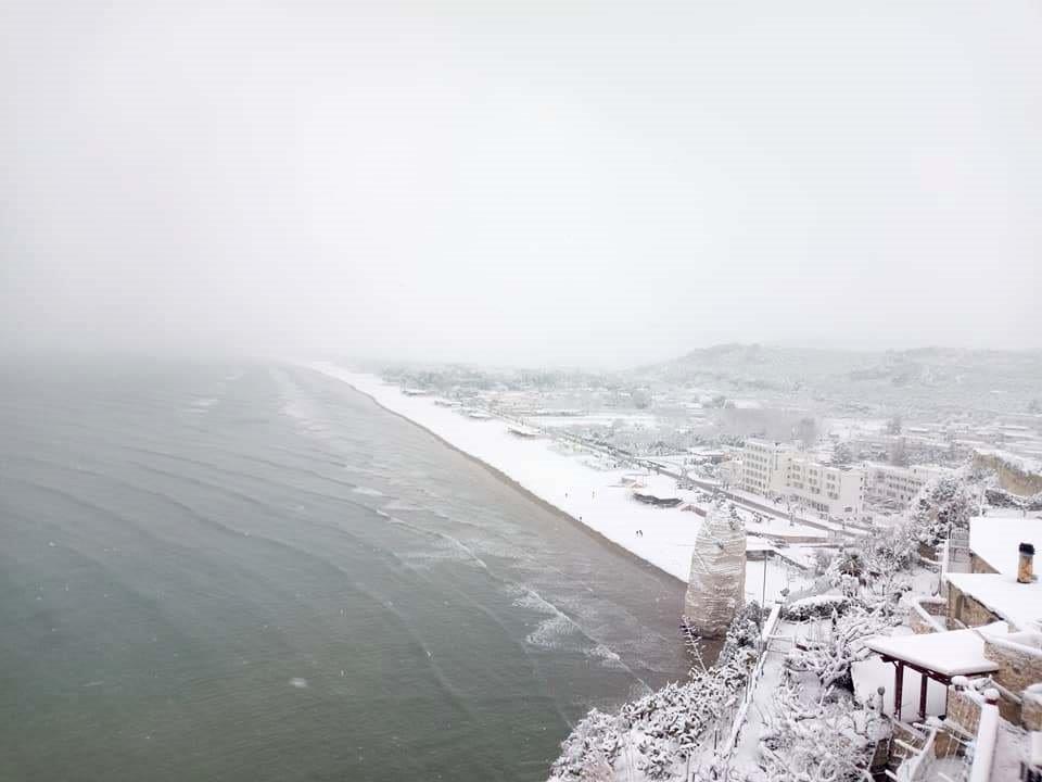 La spiaggia del Pizzomunno a Vieste in provincia di Foggia coperta dalla neve e dalla foschia