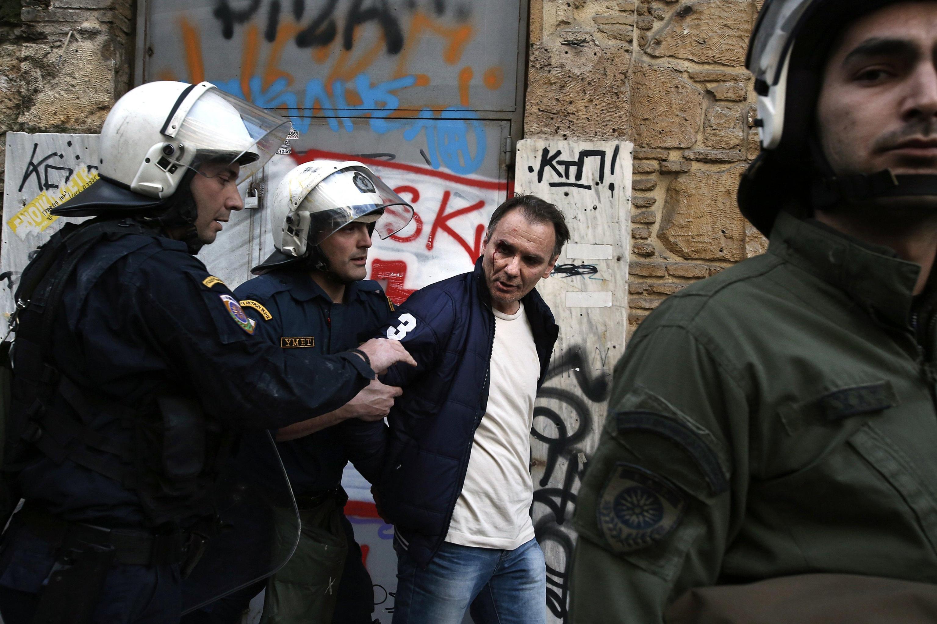 Un manifestante ferito viene portato via dagli agenti