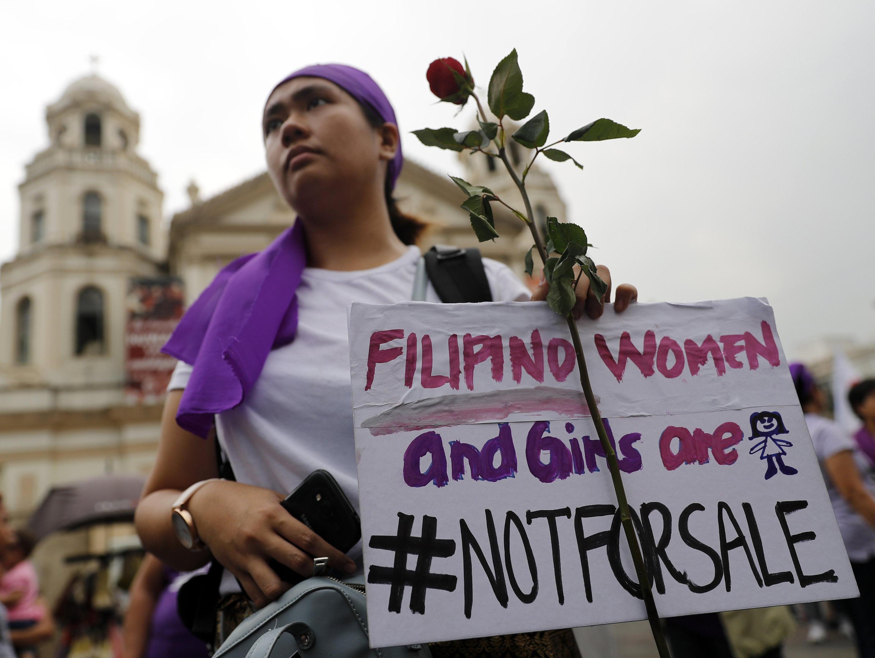 Una signora filippina immortalata durante il corteo