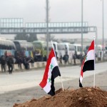 Piccole bandiere piantate da soldati siriani su un cumulo di terra