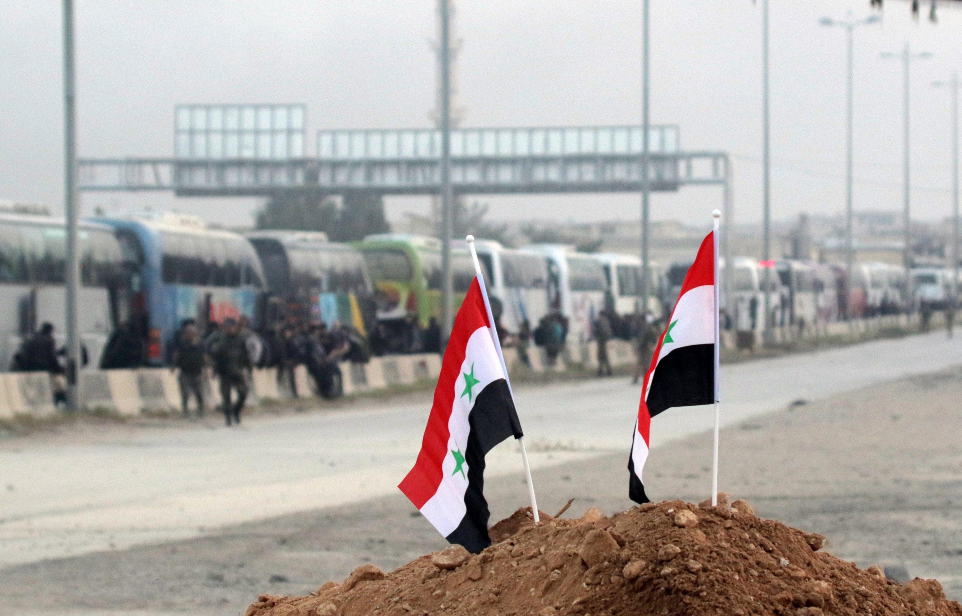 Piccole bandiere piantate da soldati siriani su un cumulo di terra
