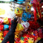 Un ragazzo appende una testa di dragone danzante nella via Hang Ma ad Hanoi. Il Mid-Autumn Festival è un festival del raccolto celebrato in particolare dai popoli cinese e vietnamita. Il festival si svolge il 15° giorno dell'8° mese del calendario lunare con la luna piena di notte,