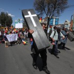 Un manifestante marcia con una finta bara per protestare contro l'uccisione di due cocaleros da parte della polizia