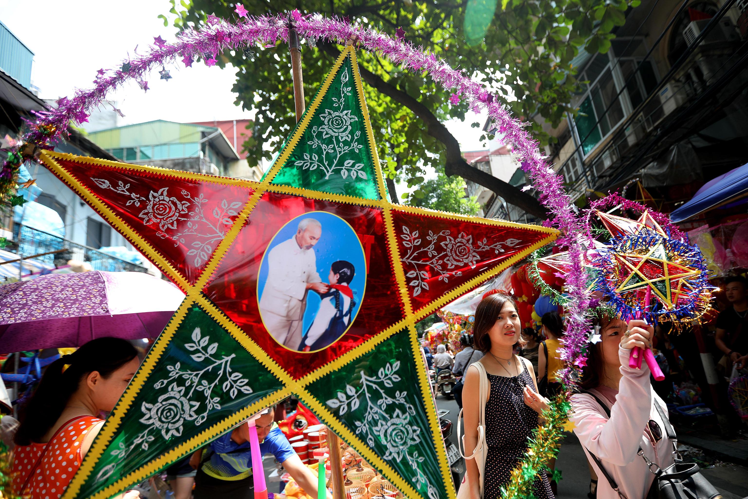 Due ragazze passeggiano vicino a un negozio di lanterne. Nome ufficiale 中秋節 il Mid-Autumn Festiaval è chiamato anche Mooncake Festival.