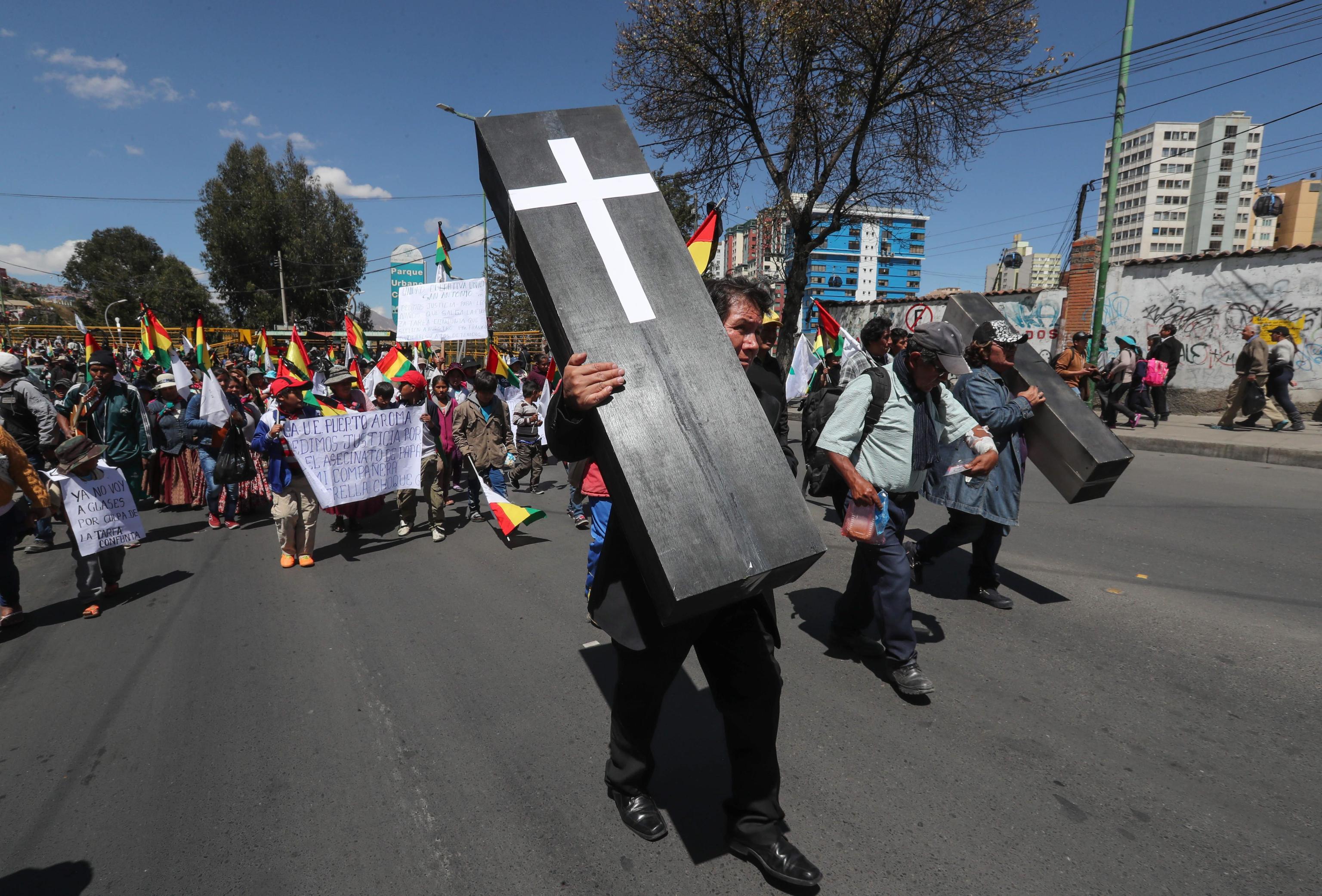 Un manifestante marcia con una finta bara per protestare contro l'uccisione di due cocaleros da parte della polizia