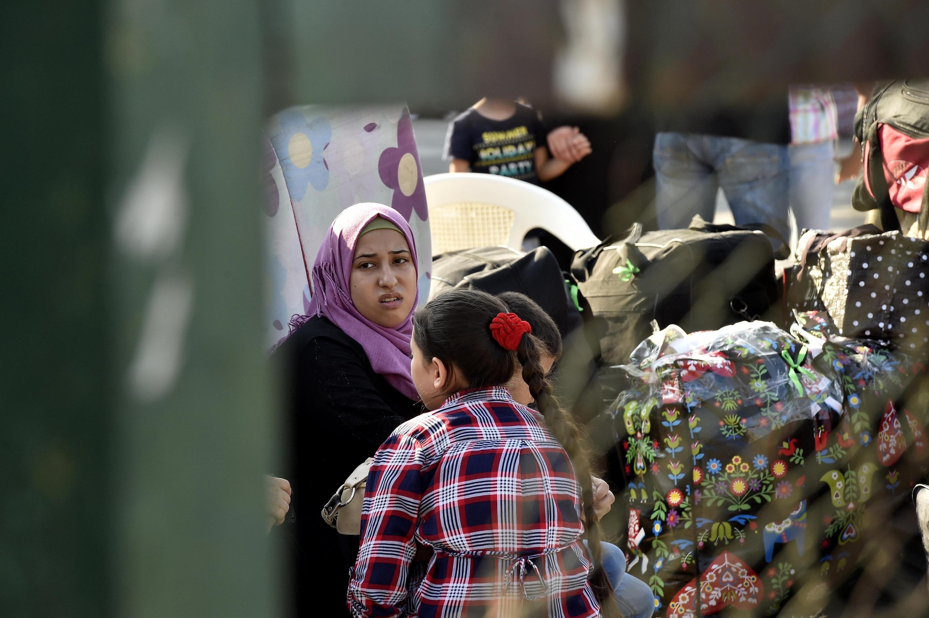 Una donna attende fra i pacchi e i bagagli nella zona della Sport City di Beirut