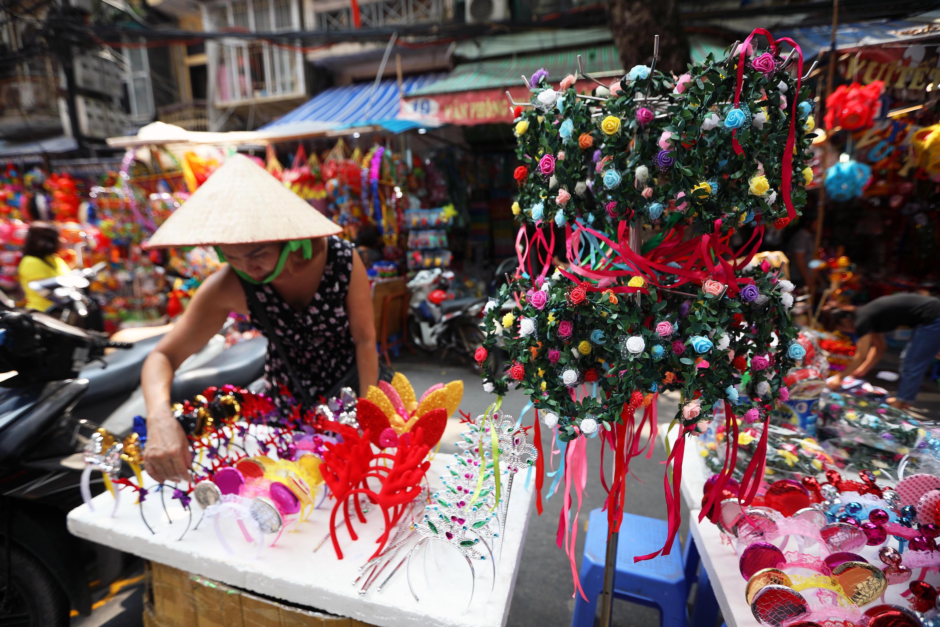 Una donna vende decorazioni ad Hanoi. Il 24 settembre tutti dovranno apparire molto colorati per celebrare il buon raccolto.