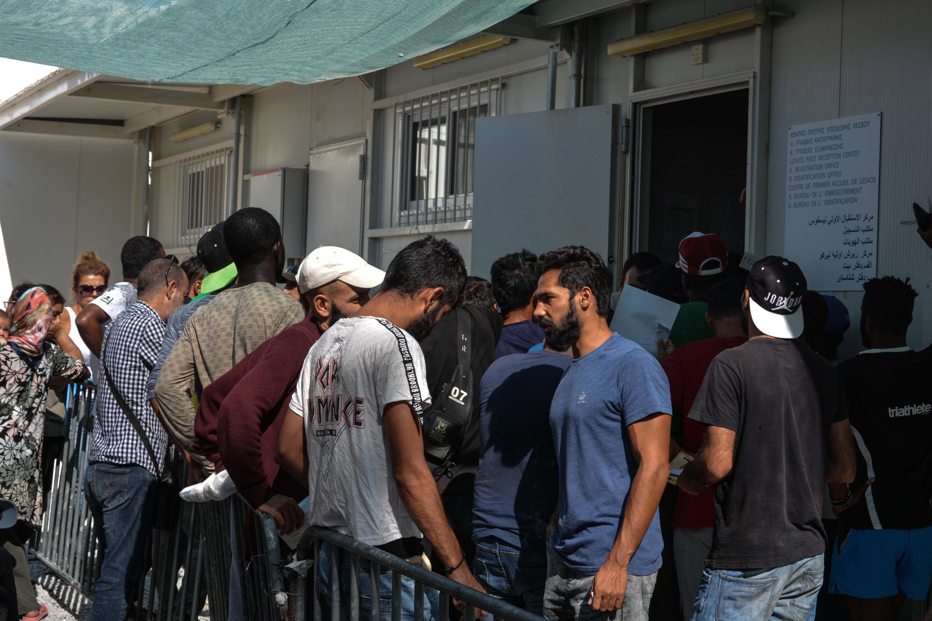 Rifugiati attendono di essere registrati nel centro per richiedenti asilo