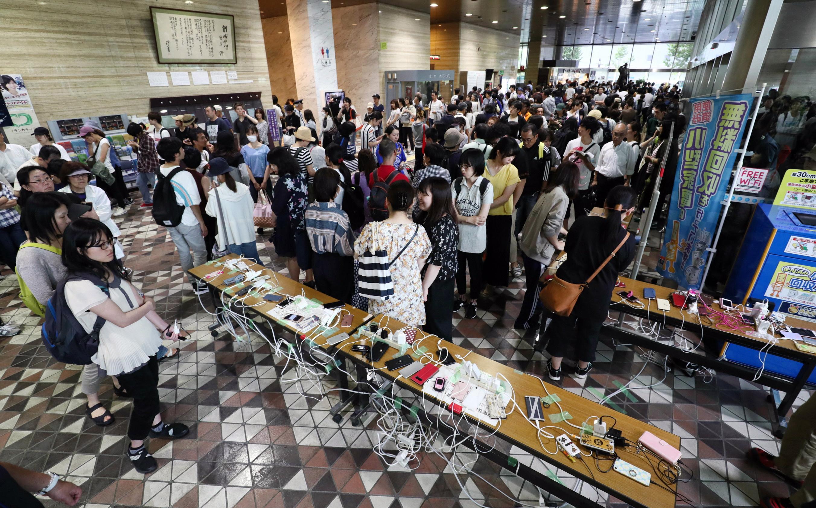 Residenti locali si radunano per cercare di ricaricare i telefoni cellulari Residenti locali si radunano per cercare di ricaricare i telefoni cellulari