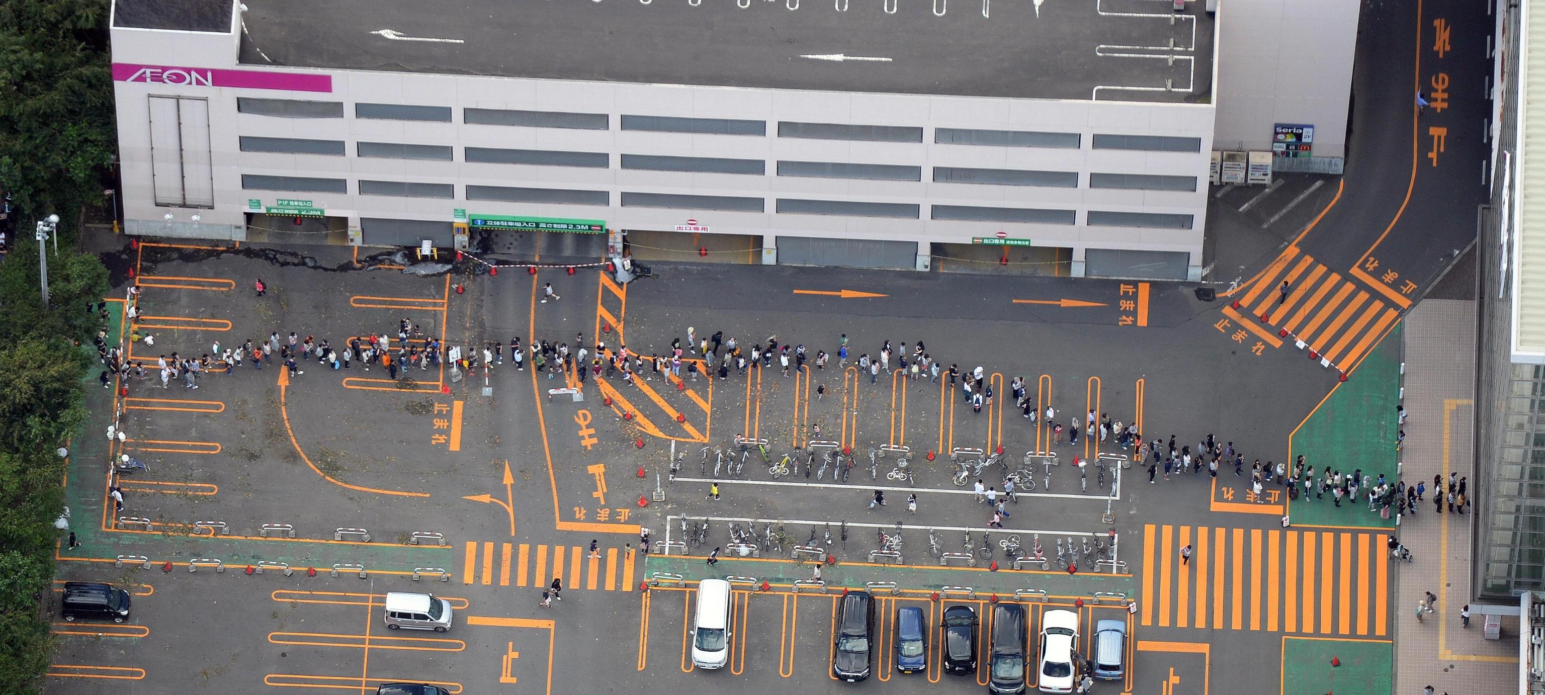 Decine di persone in fila davanti a un supermercato di Sapporo