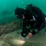 Un sub illumina lo stemma portoghese su uno dei cannoni Un sub illumina lo stemma portoghese su uno dei cannoni