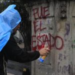 Un manifestante scrive su un muro "E' stato lo Stato", in relazione alla scomparsa degli studenti Un manifestante scrive su un muro "E' stato lo Stato", in relazione alla scomparsa degli studenti