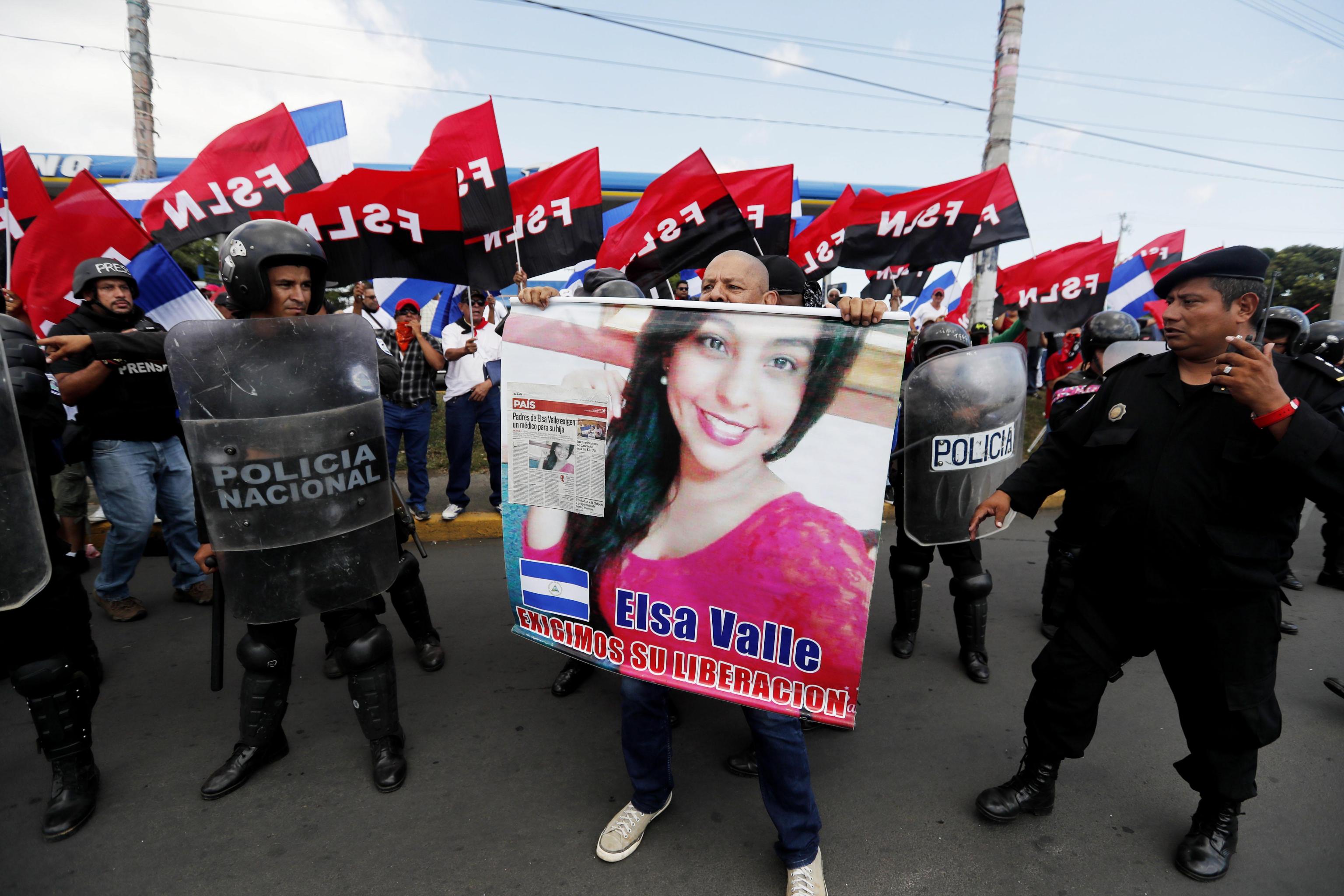 L'immagine di una prigioniera politica viene issata polemicamente davanti alla polizia e ai sostenitori del governo. L'immagine di una prigioniera politica viene issata polemicamente davanti alla polizia e ai sostenitori del governo.