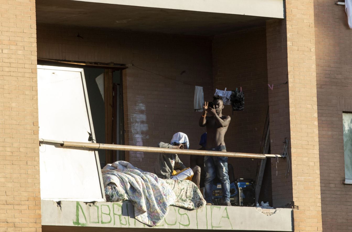 Due abitanti affacciati al balcone dello stabile occupato