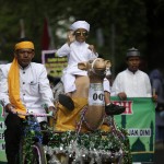 Un bambino acehnese cavalca la statua di un cammello vestito in abiti tradizionali, durante la parata per il Capodanno Islamico. Questo evento, noto come Hijra, è commemorato nell'Islam per il suo ruolo nella fondazione della prima comunità musulmana