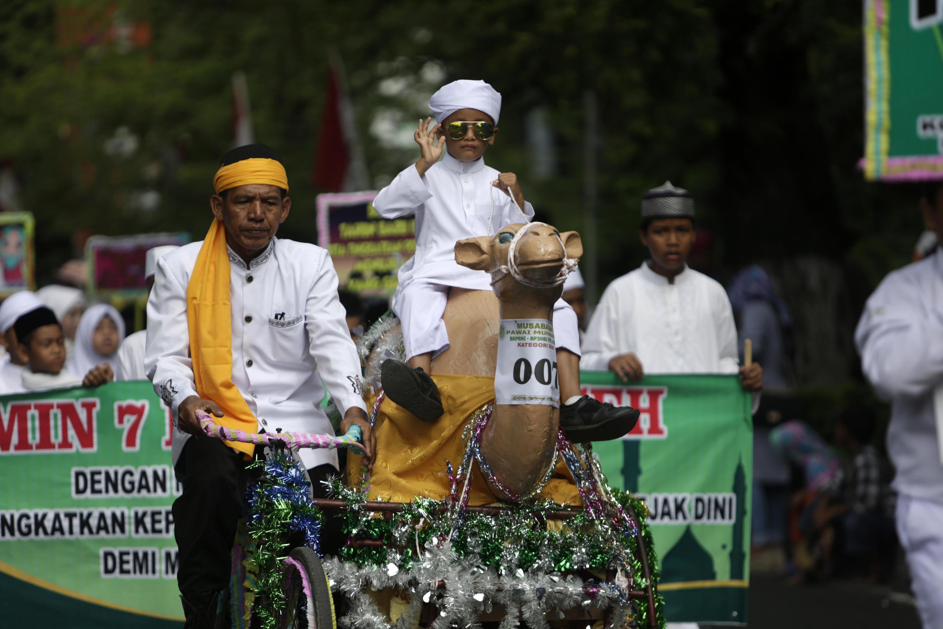 Un bambino acehnese cavalca la statua di un cammello vestito in abiti tradizionali, durante la parata per il Capodanno Islamico. Questo evento, noto come Hijra, è commemorato nell'Islam per il suo ruolo nella fondazione della prima comunità musulmana