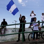 Un giovane manifesta sventolando la bandiera del paese centroamericano. Un giovane manifesta sventolando la bandiera del paese centroamericano.