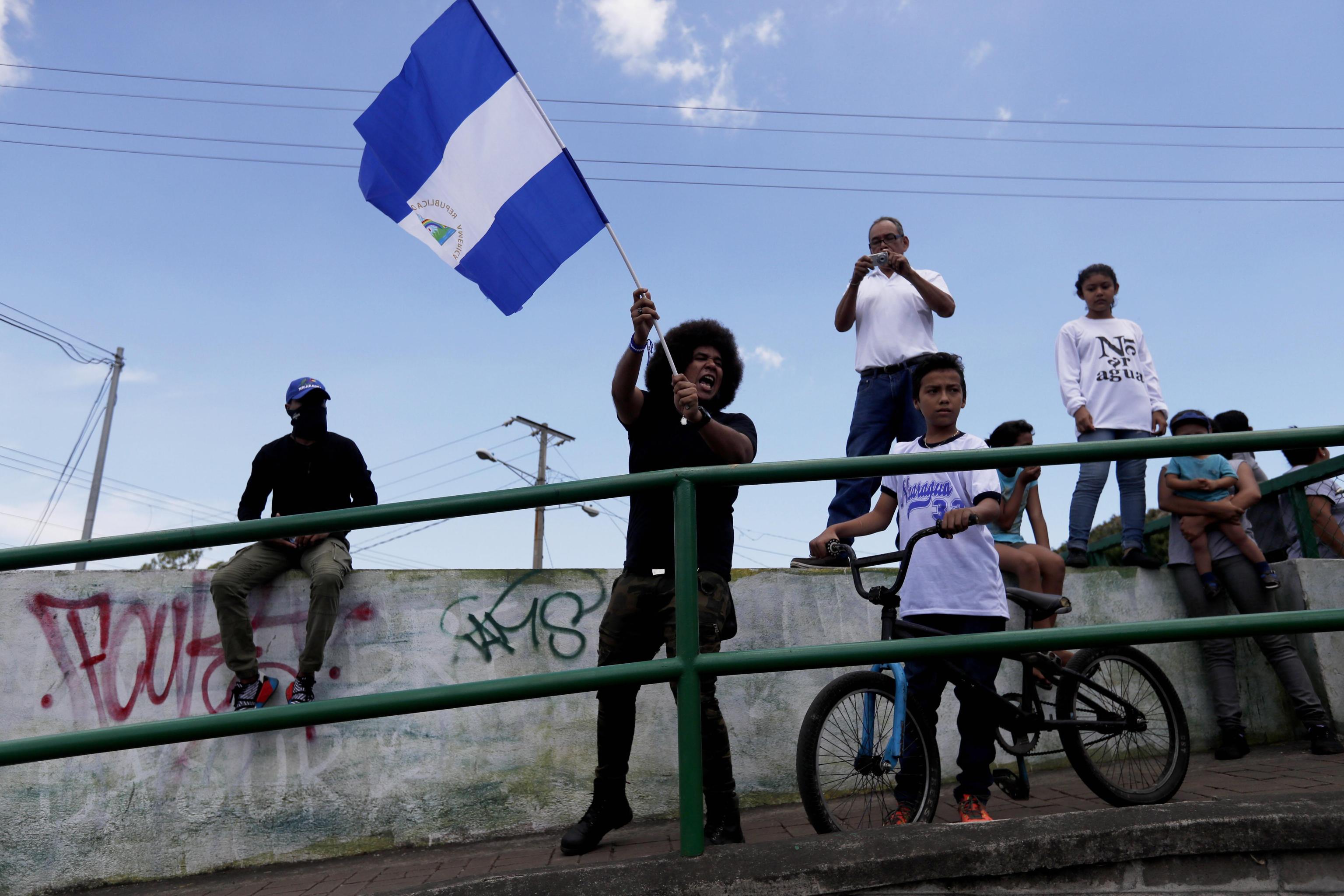 Un giovane manifesta sventolando la bandiera del paese centroamericano.