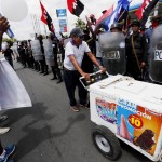 Un venditore di gelati passa tra i due gruppi di manifestanti contrapposti. Un venditore di gelati passa tra i due gruppi di manifestanti contrapposti.