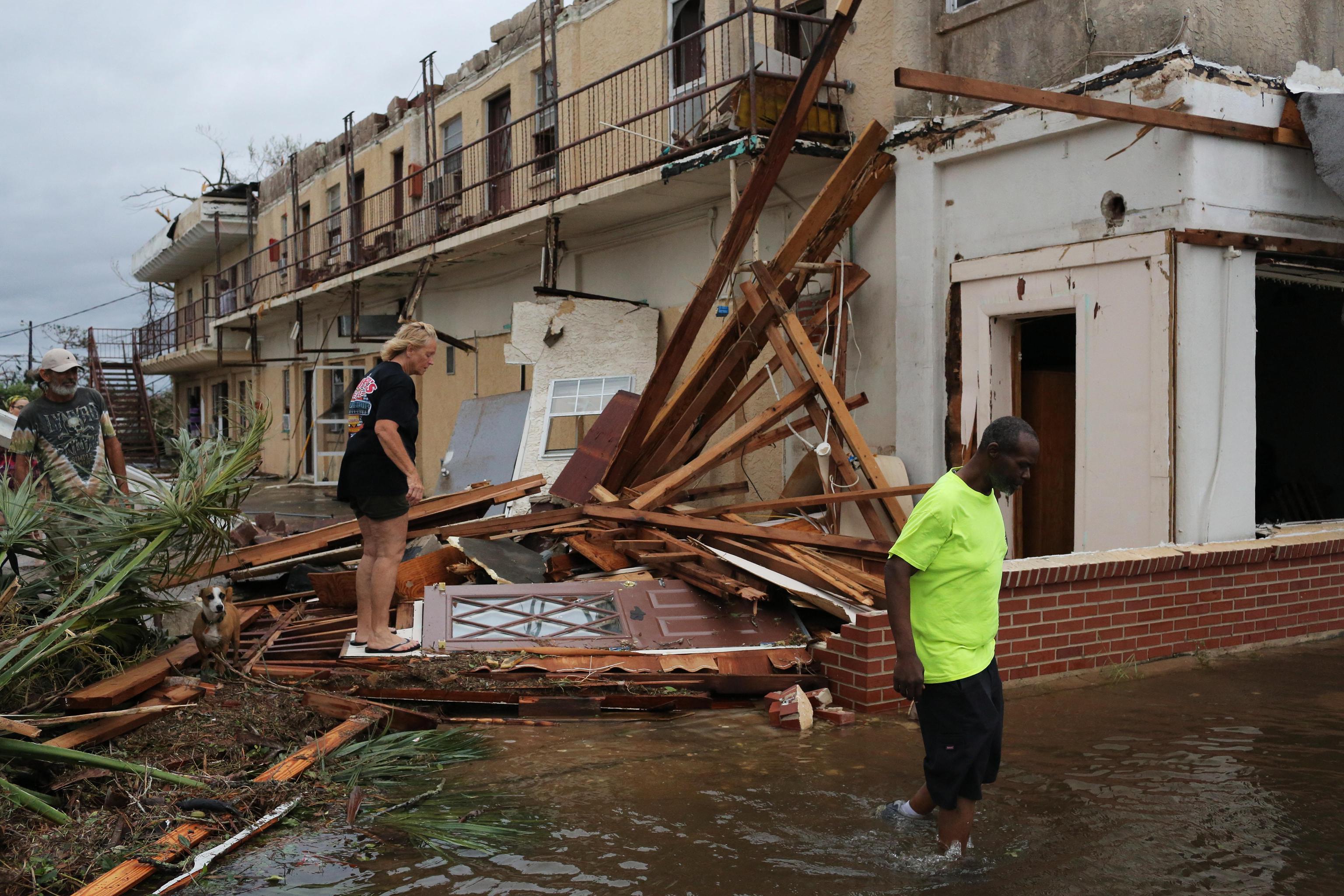 Persone camminano attraverso alcune abitazioni di Panama City devastate dall'urgano