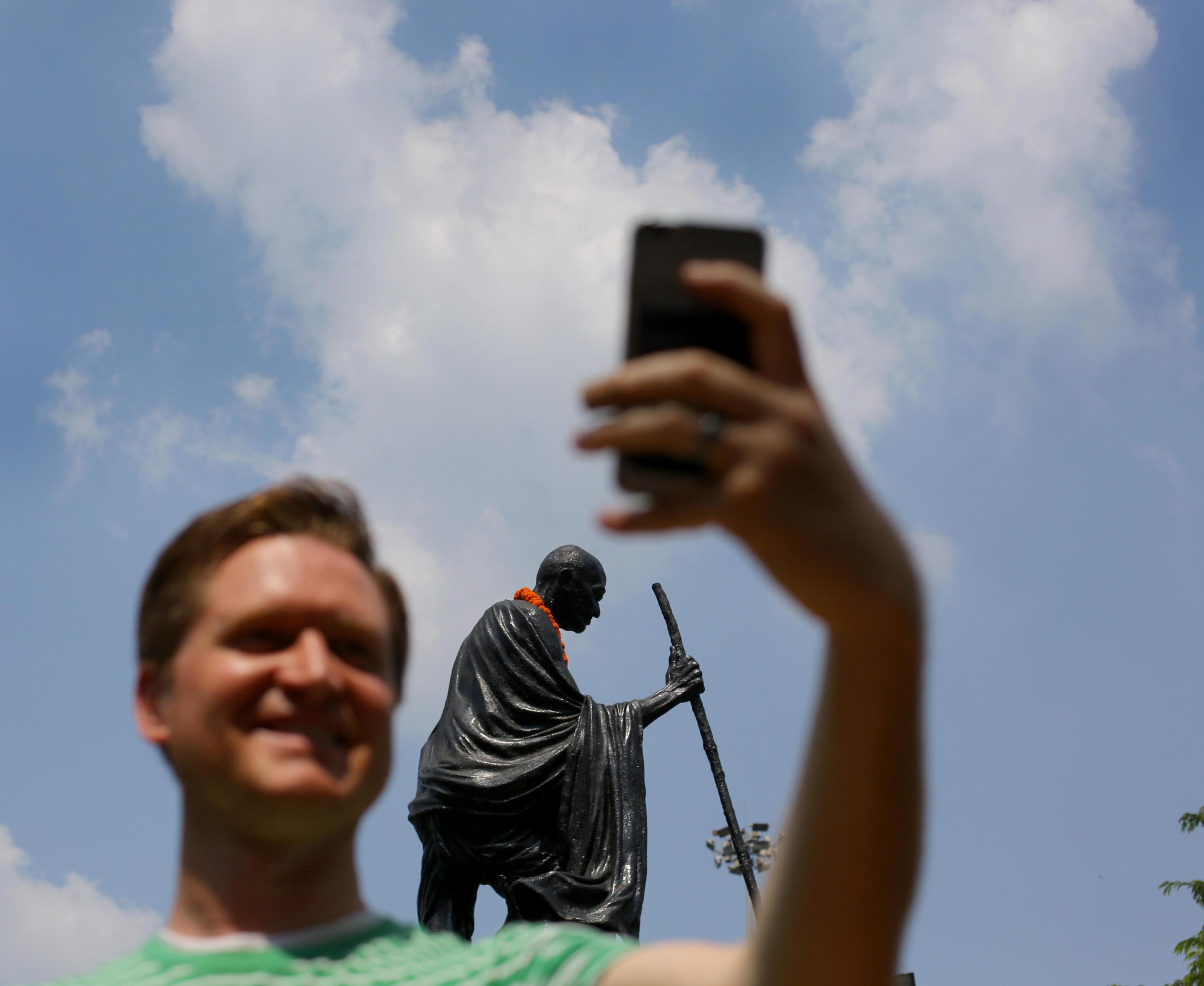 Un turista fotografa la statua con il suo smartphone