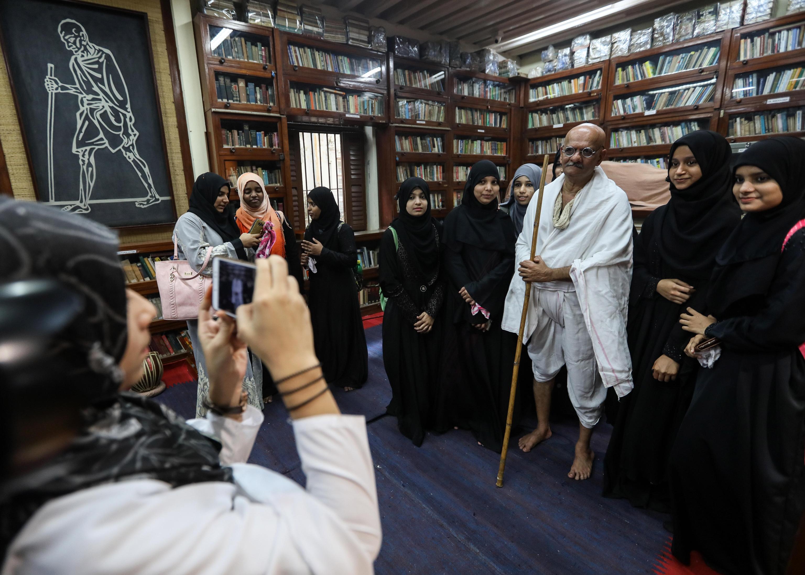 Un uomo ricorda il Mahatma Gandhi indossando gli stessi abiti