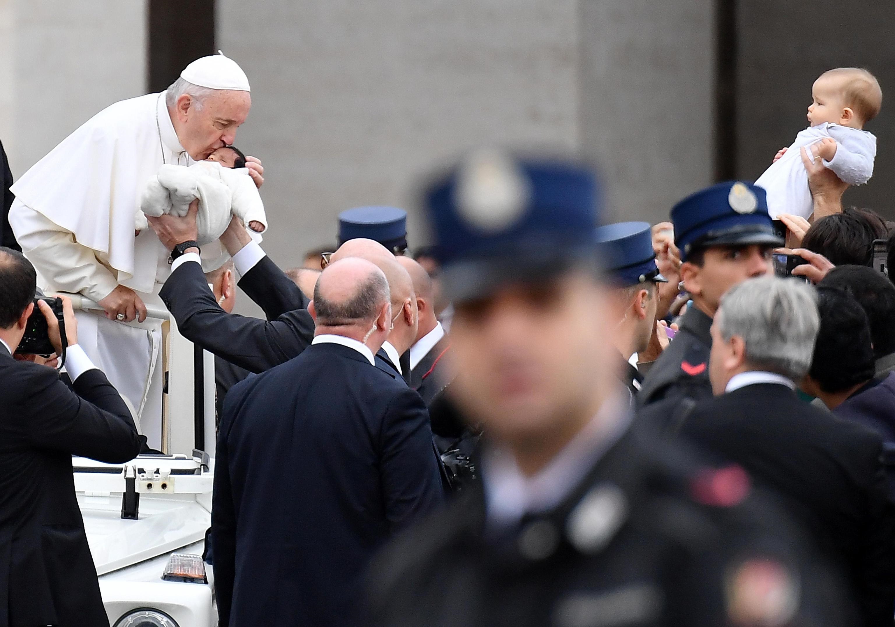 Papa Francesco osserva i bambini in prima fila durante l'udienza generale.