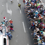 Membri della Croce Rossa consegnano l'acqua ai migranti honduregni