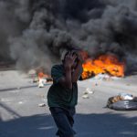 Un bambino si protegge il capo durante le proteste Un bambino si protegge il capo durante le proteste