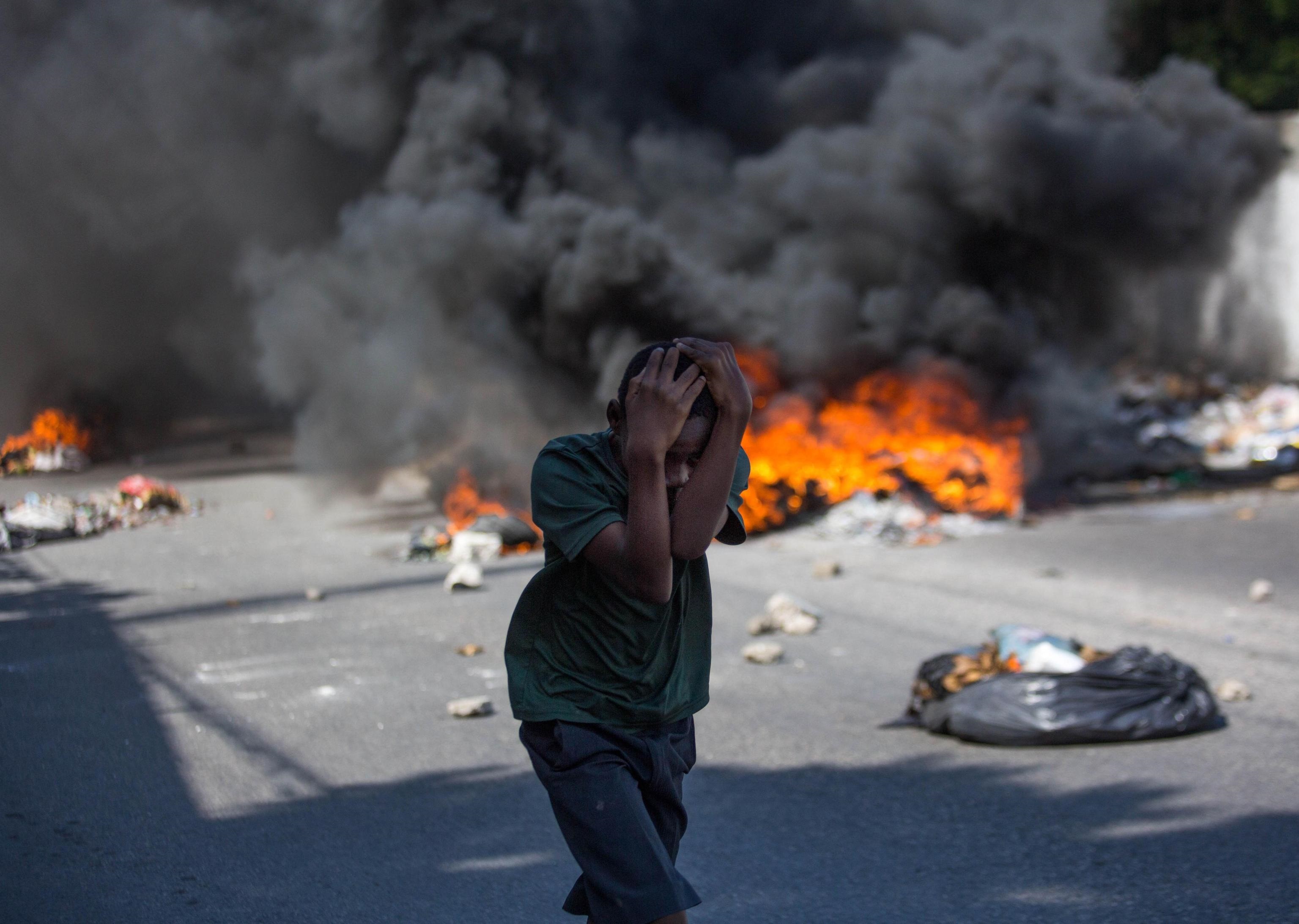 Un bambino si protegge il capo durante le proteste Un bambino si protegge il capo durante le proteste