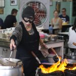 La chef e proprietaria del Raan Jay Fai, Supinya Chansuta, mentre cucina con la sua mascherina