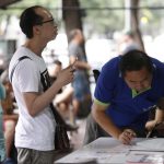 I clienti scrivono il loro nome su un'apposita lista per prenotare un posto al Raan Jay Fai