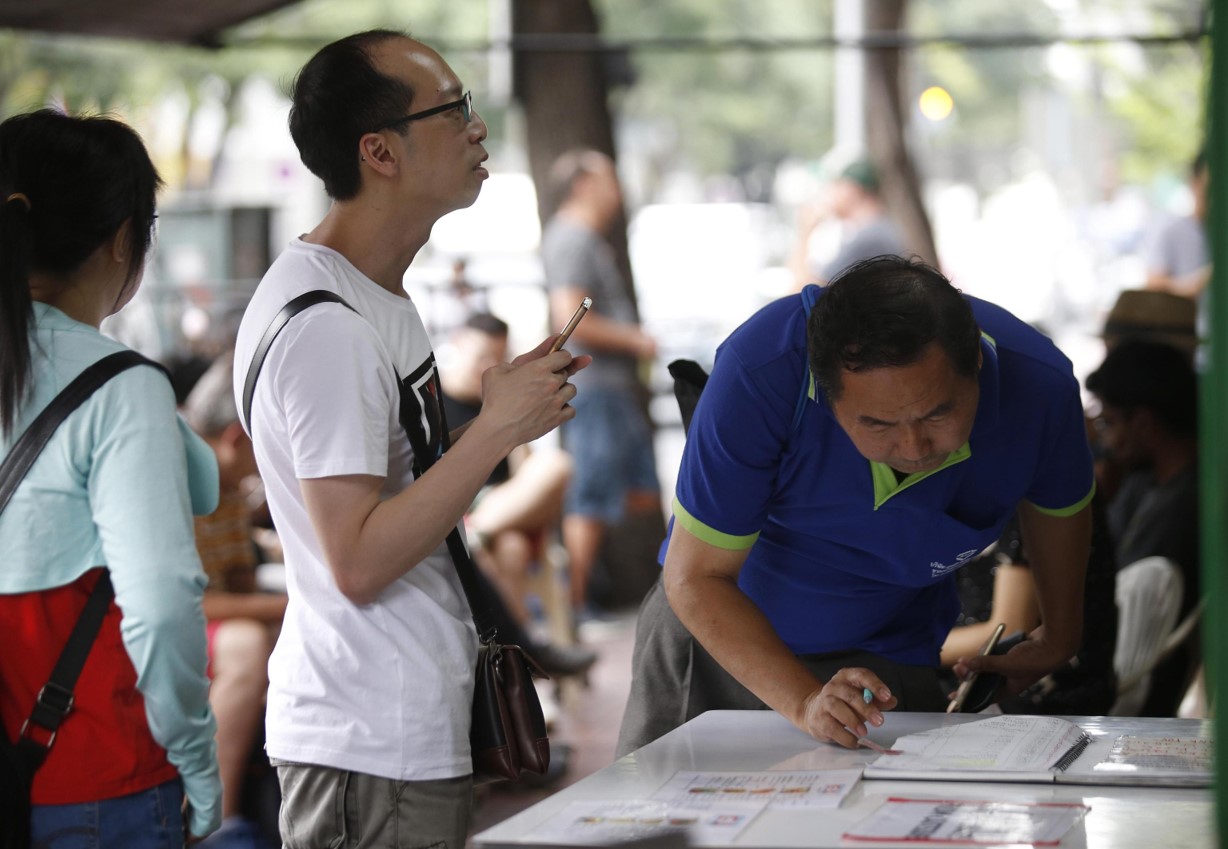 I clienti scrivono il loro nome su un'apposita lista per prenotare un posto al Raan Jay Fai