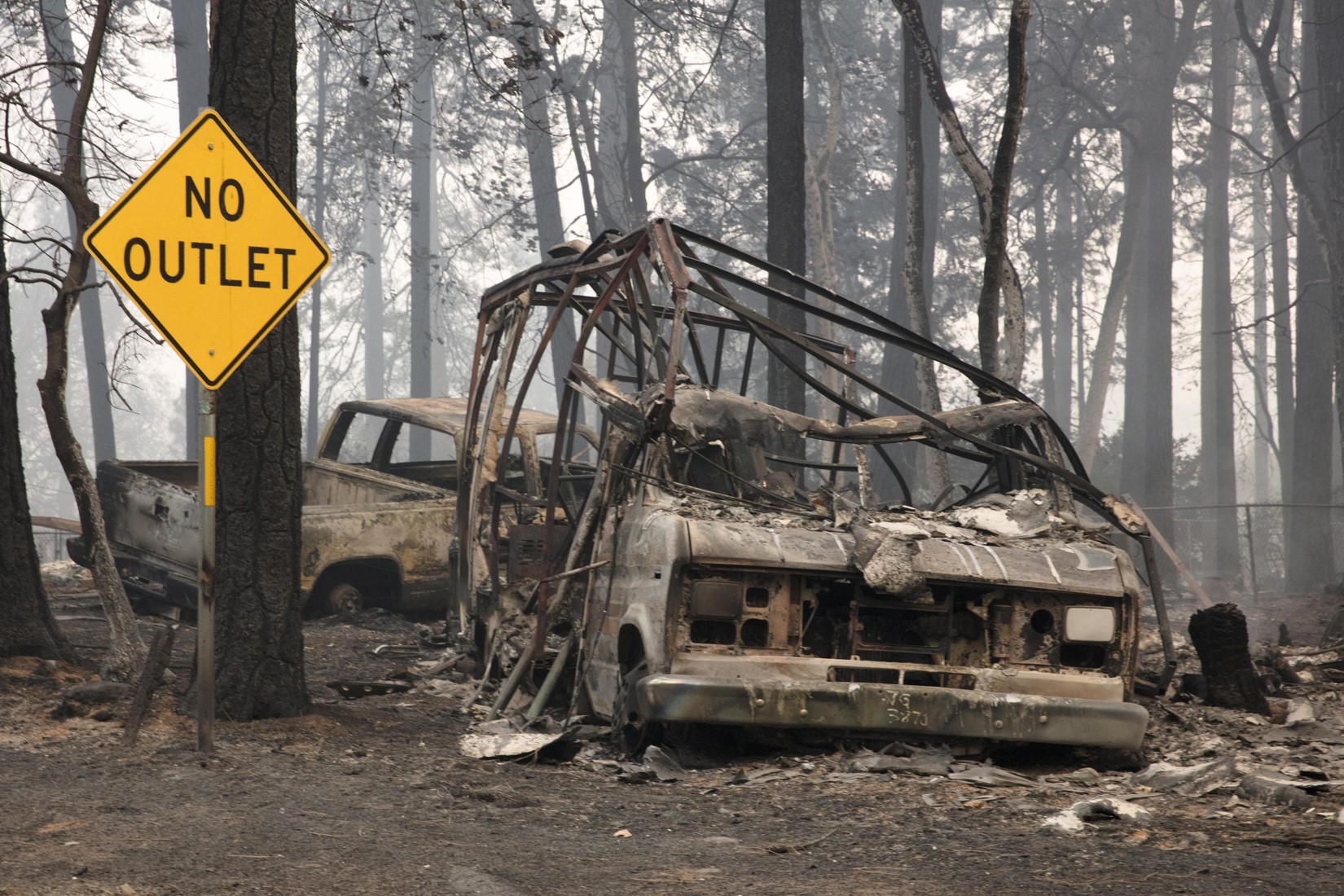 Un veicolo bruciato accanto ad un cartello tristemente ironico nell'area di Pentz Road (Contea di Butte, California)