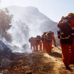 I vigili del fuoco lavorano per spegnere le fiamme su una collina a West Hills (Contea di Butte, California)